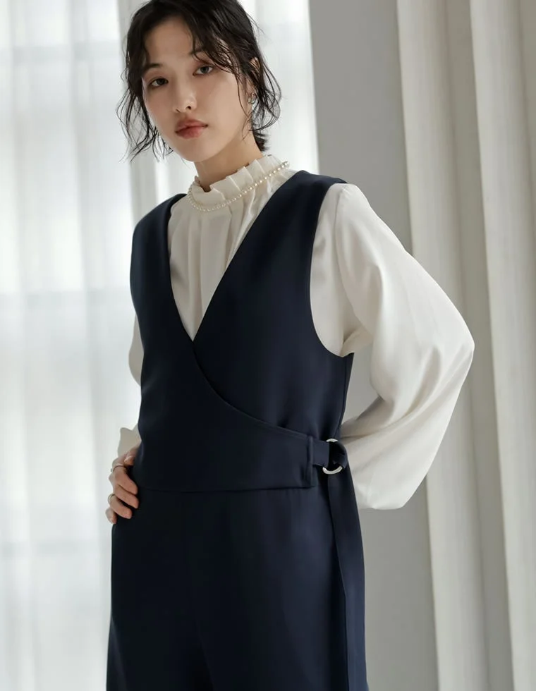 白いフリルブラウスとネイビーのVネックジャンパースカート