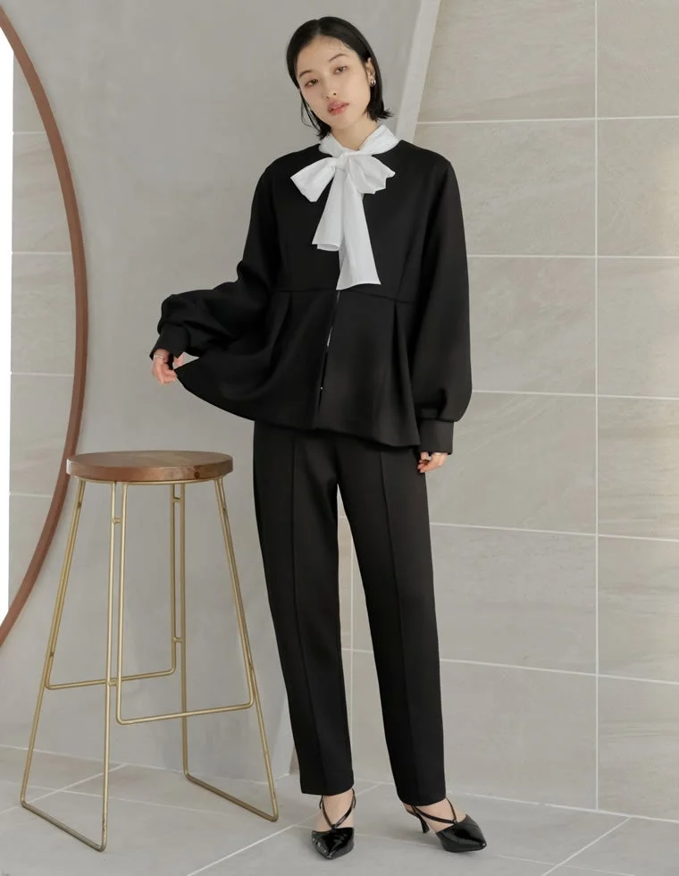 黒いペプラムトップスとパンツのセットアップ、白い大きなリボン