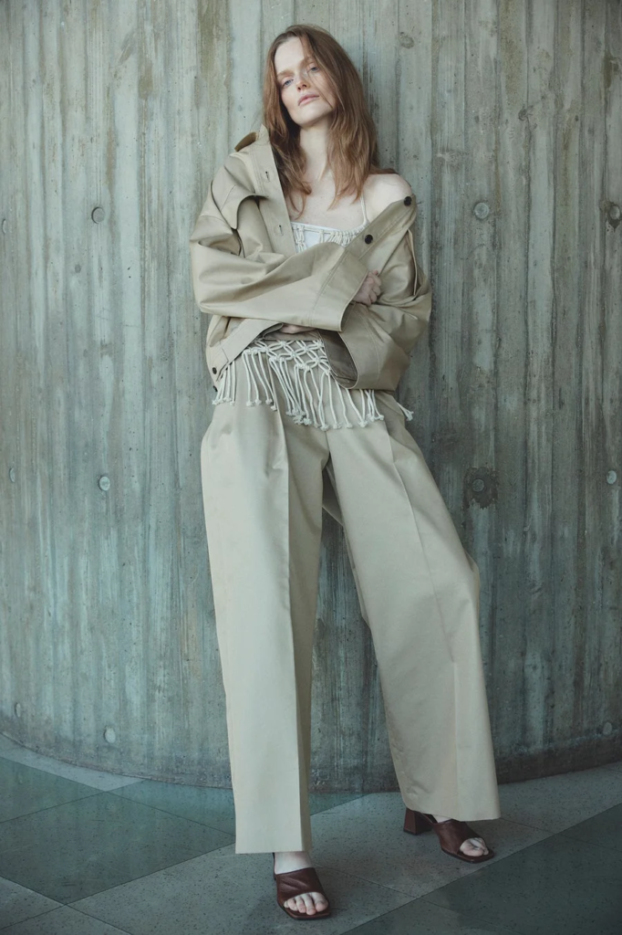 ベージュのジャケットとワイドパンツを着用した女性モデル
