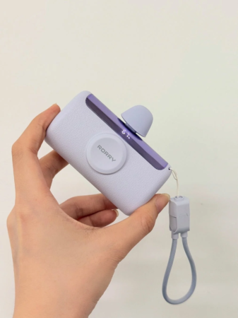 女性の手に持たれた、パープルとホワイトのスタイリッシュなポータブル充電器