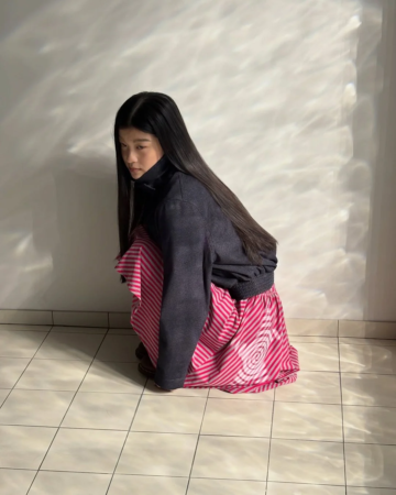 ストライプスカートを着用ししゃがむ女性