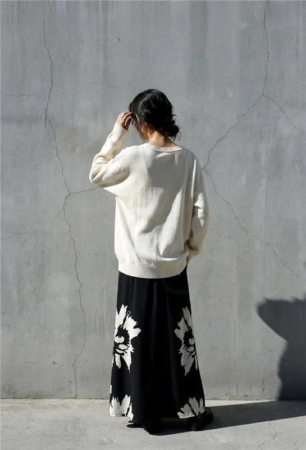 女性がスカートを着用している後ろ姿の写真