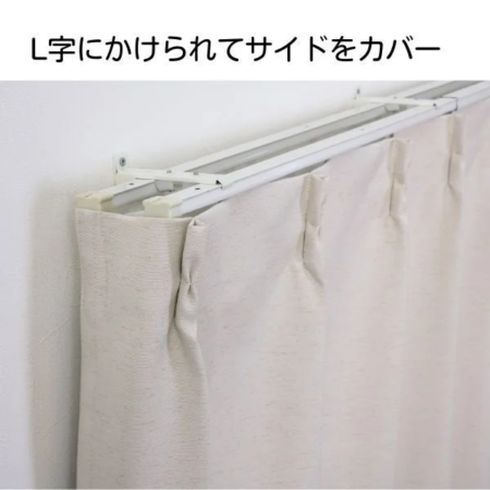 L字型に設置されたカーテンレールにベージュのカーテンがかかっており、サイドもしっかりとカバーしている様子が写されています。