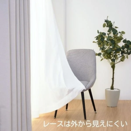風になびく白いレースカーテンが特徴的な明るい室内。