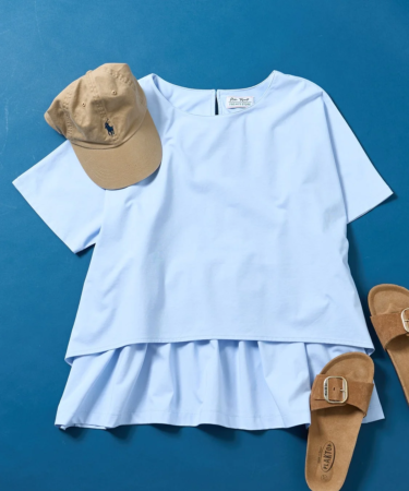 水色のトップス、ベージュのキャップ、茶色のサンダルが青い背景に置かれたカジュアルな夏服のコーディネートです。