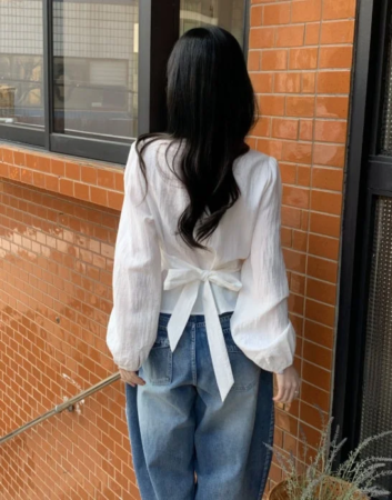 白いリボン付きブラウスとデニムパンツ