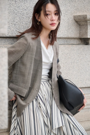 ブラウンのブレザー、白いドレープトップス、ストライプのロングスカート