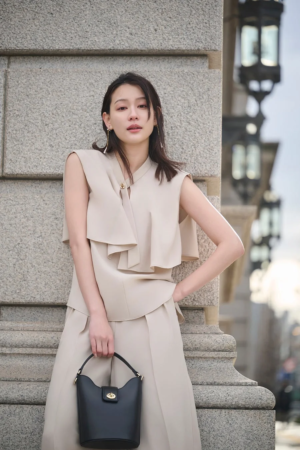 ベージュのノースリーブブラウスとワイドパンツ