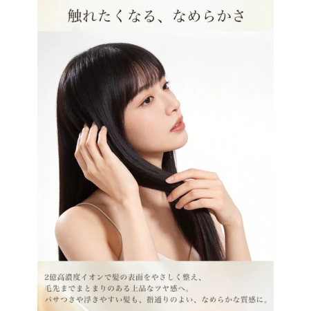 黒髪の女性が自身の髪に触れ、そのなめらかで上品な質感をアピールしています