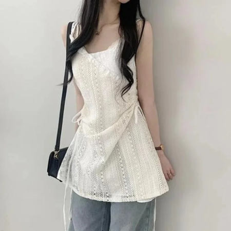 白いレース編みのキャミソールトップスを着用した女性