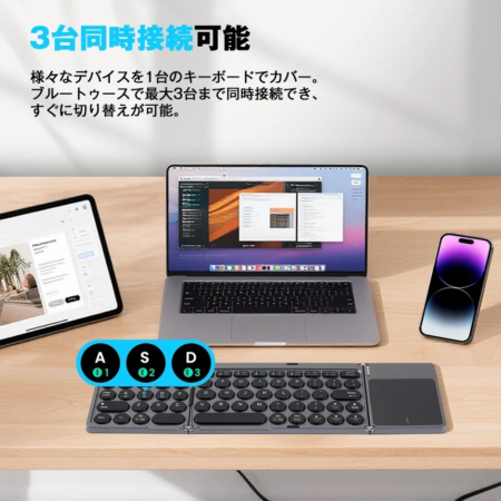 折りたたみ式のワイヤレスキーボードが、ノートパソコン、タブレット、スマートフォンの3台に同時接続されている様子