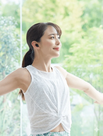 ヨガをする女性がワイヤレスイヤホンを装着