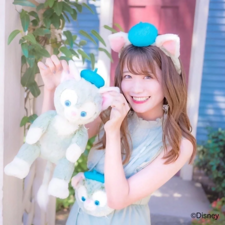 ジェラトーニのぬいぐるみとカチューシャを身につけた笑顔の女性