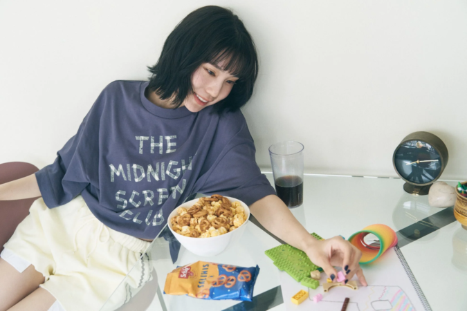 若い女性がポップコーンを食べながらくつろぐ様子