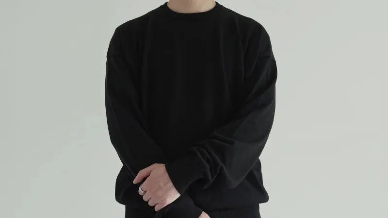 黒の長袖トップスを着た人物のバストアップ写真