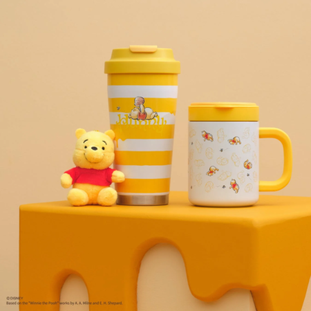 くまのプーさんのぬいぐるみ、タンブラー、マグカップが並べられた商品ディスプレイ