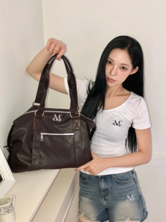 ダークブラウンのバッグを持った女性の全身ショット