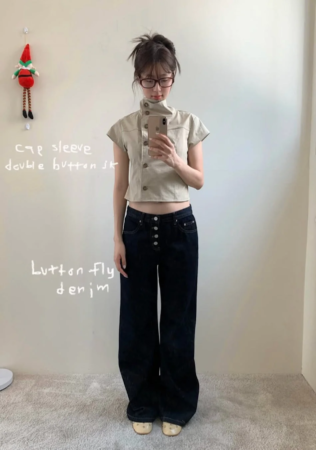 ベージュのキャップスリーブダブルボタンのトップスとワイドデニムパンツを着用した女性のコーディネート