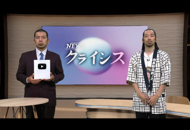 番組スタジオで銀の盾を持つ出演者