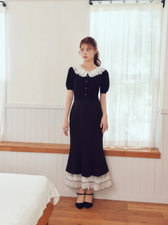 白いレース襟と裾のフリルが特徴的な黒いワンピース