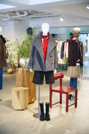 グレーのショートコートと赤いトップス、黒のショートパンツを着用したマネキン