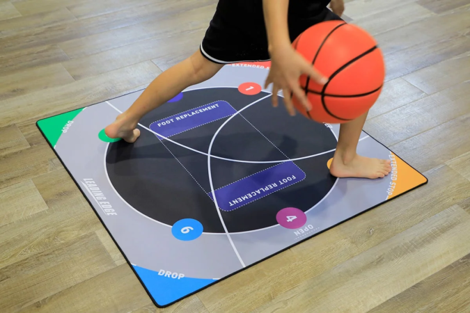 バスケットボールのドリブル練習をする子供の姿