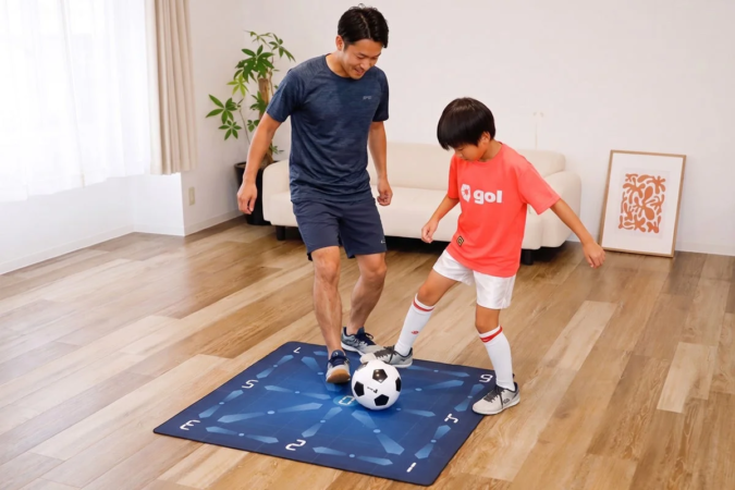 リビングルームで父親と息子がサッカーボールとトレーニングマットを使って練習