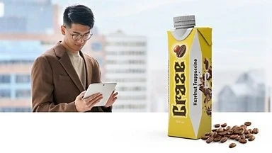 コーヒー飲料とタブレットを見る男性